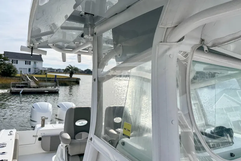 Slide: The Image of 2021 Cape Horn 31 T boat with clear enclosure, docked near waterfront homes. - 18