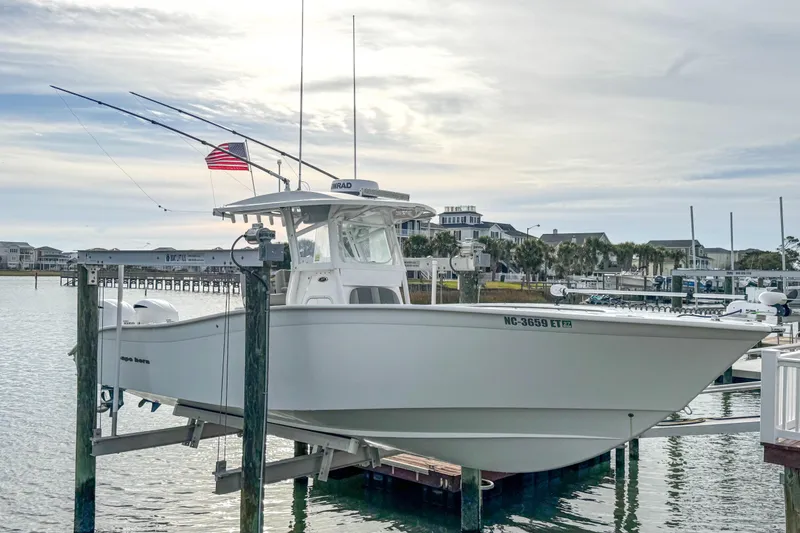 Slide: The Image of 2021 Cape Horn 31 T boat on lift, docked by waterfront with American flag. - 3
