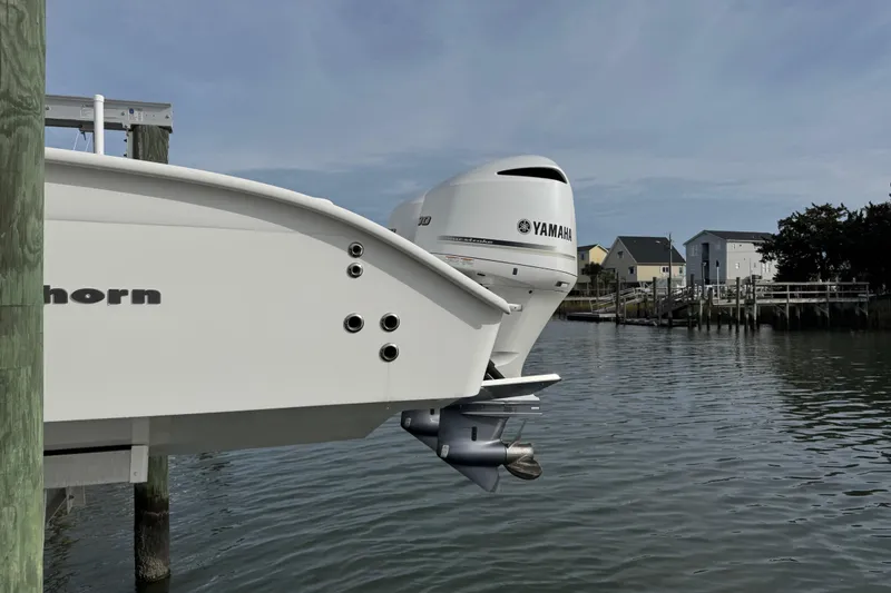 Slide: The Image of Cape Horn 31 T boat with Yamaha outboard motor, docked near waterfront homes. - 5