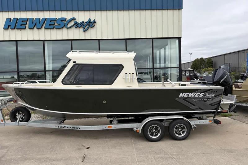 Slide: The Image of 2026 Hewescraft 240 Ocean Pro ET Hardtop boat on trailer outside showroom. - 2