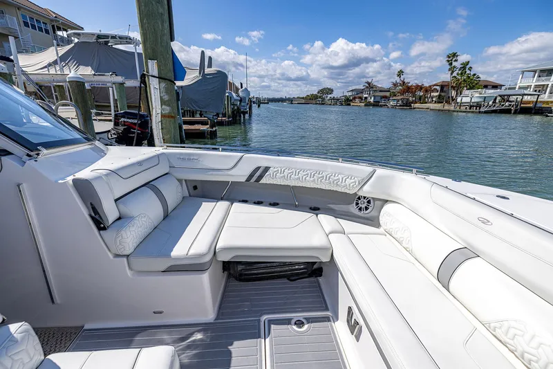 Slide: The Image of Luxurious 2022 Regal LX36 boat interior with plush seating, docked by a scenic waterfront. - 11