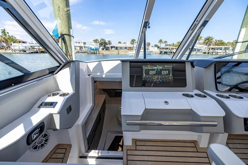Slide: The Image of 2022 Regal LX36 boat interior with modern dashboard and scenic waterfront view. - 20