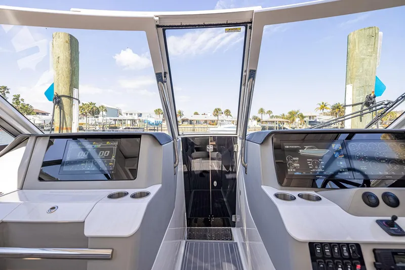 Slide: The Image of 2022 Regal LX36 boat cockpit with modern dashboard and waterfront view. - 23