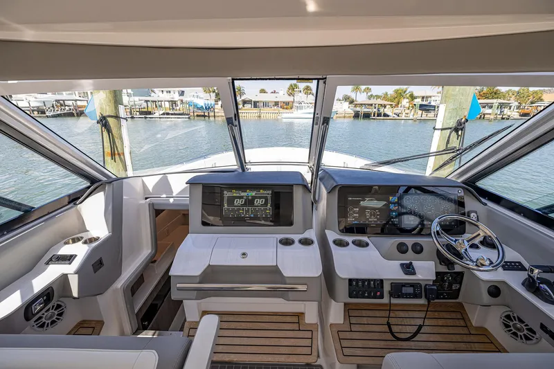 Slide: The Image of 2022 Regal LX36 boat helm with modern controls and waterfront view. - 24