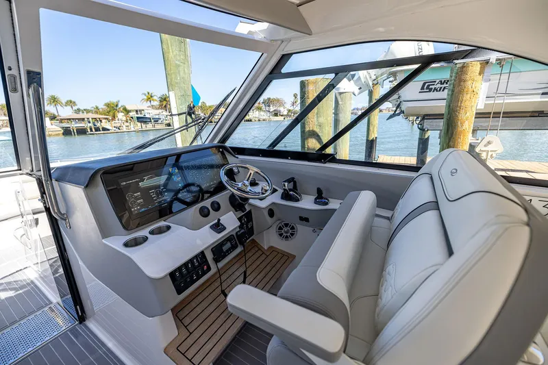 Slide: The Image of 2022 Regal LX36 boat interior with modern helm, steering wheel, and waterfront view. - 28