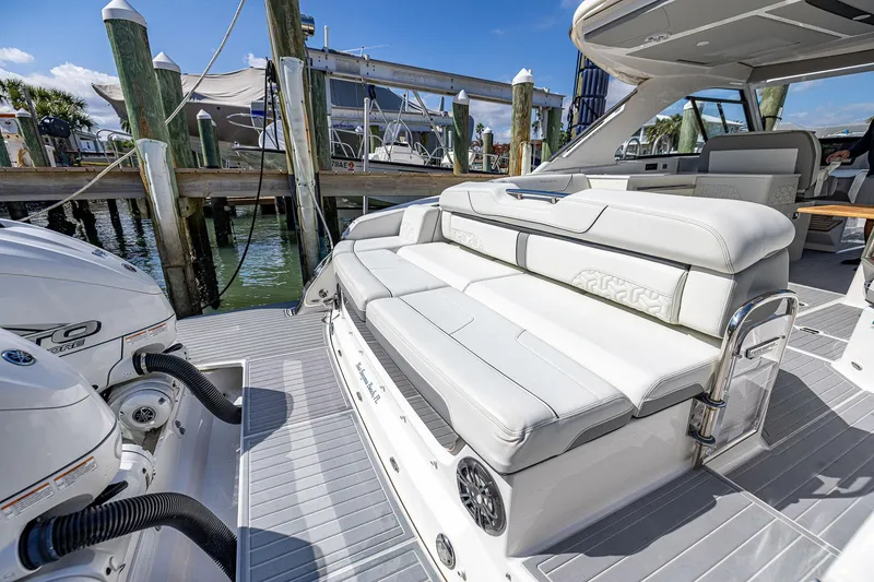 Slide: The Image of 2022 Regal LX36 luxury boat with white seating, docked at marina. - 45