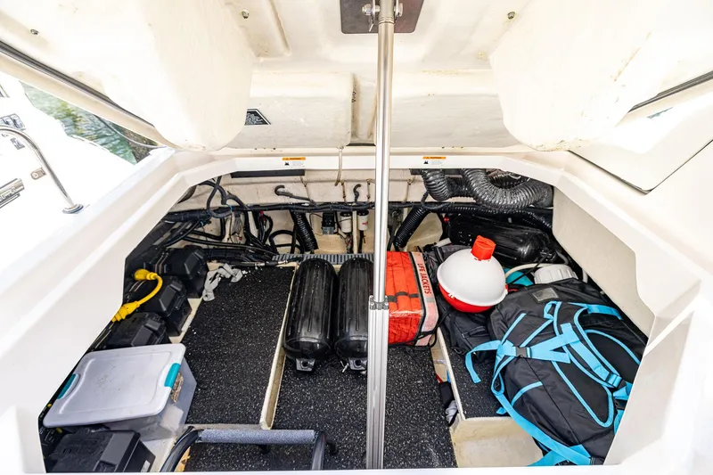 Slide: The Image of 2022 Regal LX36 boat storage compartment with equipment and gear neatly organized. - 49