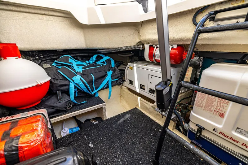 Slide: The Image of 2022 Regal LX36 boat storage area with equipment, bags, and safety gear. - 52