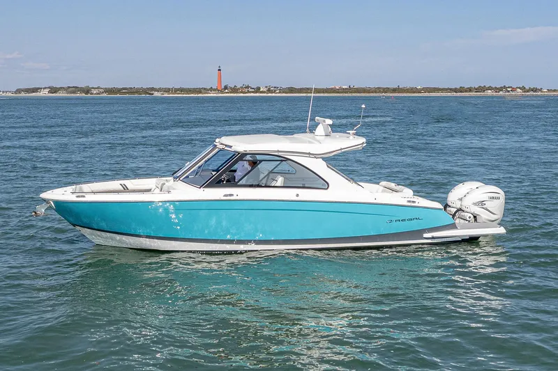 Slide: The Image of 2022 Regal LX36 boat on water with distant lighthouse view. - 6