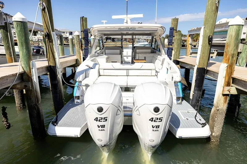 Slide: The Image of 2022 Regal LX36 boat docked, featuring twin 425 V8 engines, in a marina setting. - 65