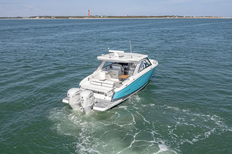 Slide: The Image of 2022 Regal LX36 boat cruising on open water with twin Yamaha engines. - 68