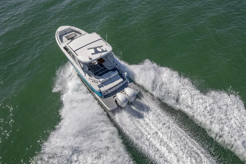 Slide: The Image of 2022 Regal LX36 boat cruising on open water, aerial view. - 69