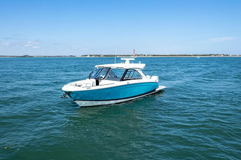 Slide: The Image of 2022 Regal LX36 boat on open water under clear blue sky. - 73