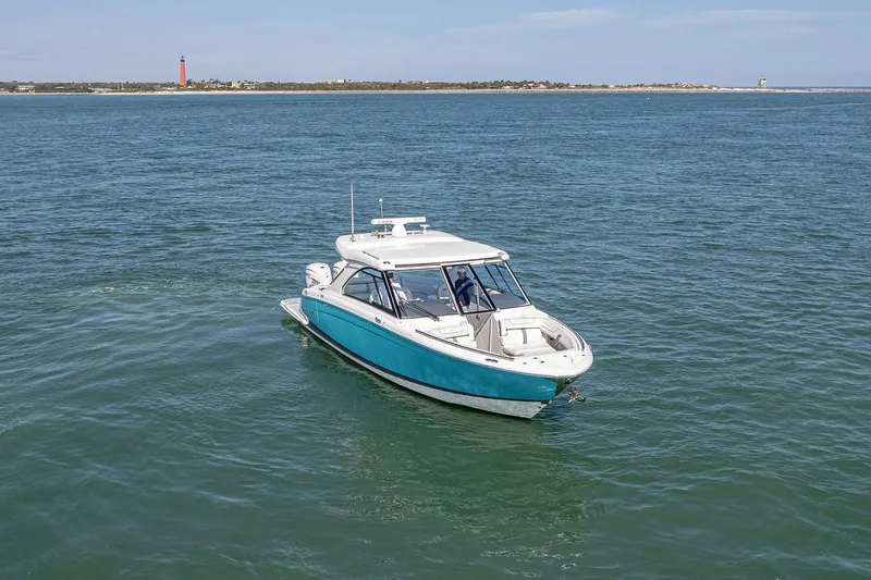 Slide: The Image of 2022 Regal LX36 boat cruising on open water with distant shoreline view. - 75