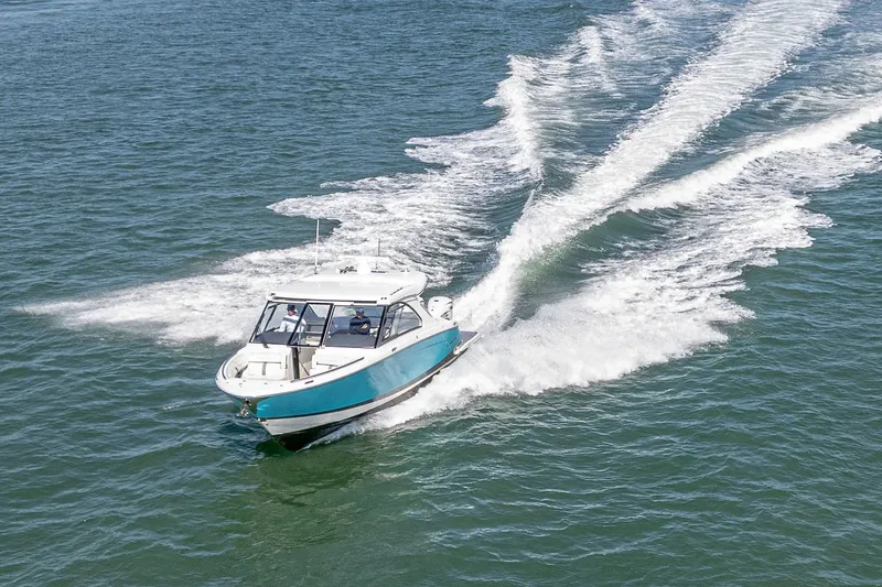 Slide: The Image of 2022 Regal LX36 boat cruising on open water, leaving a wake trail. - 78