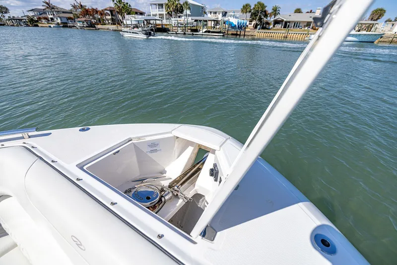 Slide: The Image of 2022 Regal LX36 boat with open anchor compartment on calm water. - 8