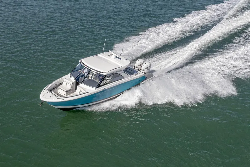 Slide: The Image of 2022 Regal LX36 boat cruising on open water, creating a dynamic wake. - 80