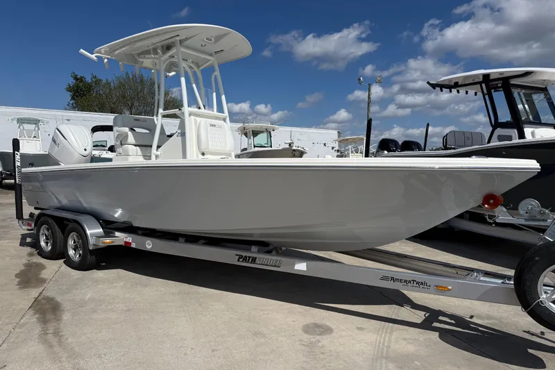 The Image of 2026 Pathfinder 2500 Hybrid boat on trailer under blue sky. - 1