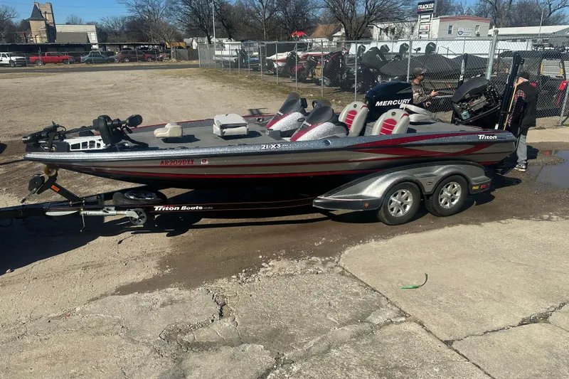 The Image of 2009 Triton 21X3 Pro DC boat on trailer, parked outdoors, with Mercury engine. - 0