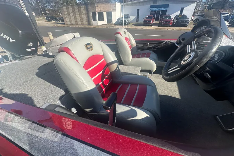 Slide: The Image of 2009 Triton 21X3 Pro DC boat interior with red and gray seats, steering wheel visible. - 10