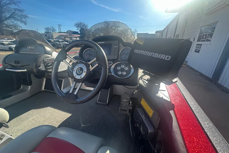 Slide: The Image of 2009 Triton 21X3 Pro DC boat cockpit with steering wheel and Humminbird electronics. - 11