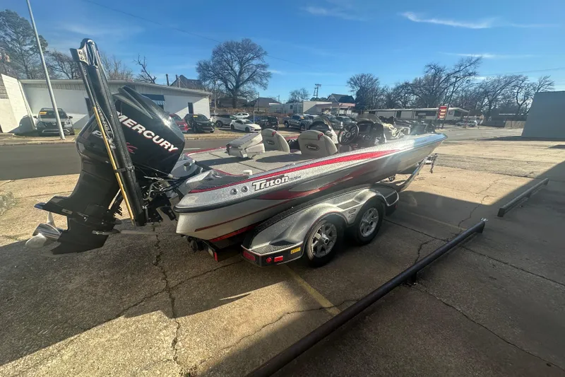 Slide: The Image of 2009 Triton 21X3 Pro DC boat with Mercury engine on trailer, parked outdoors. - 12