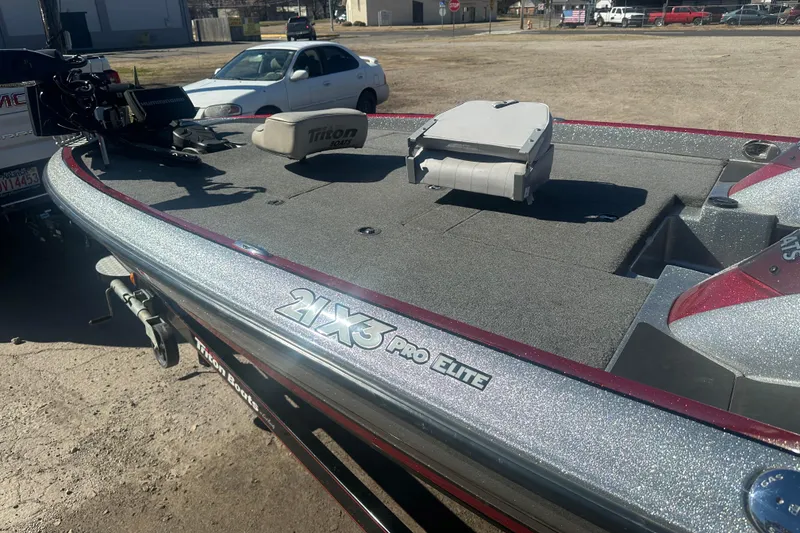 Slide: The Image of 2009 Triton 21X3 Pro DC boat, silver deck, parked outdoors. - 18