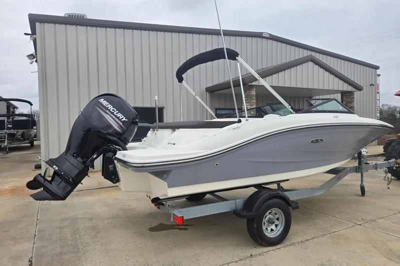 Slide: The Image of 2019 Sea Ray SPX 190 Outboard boat on trailer, parked outside a building. - 2