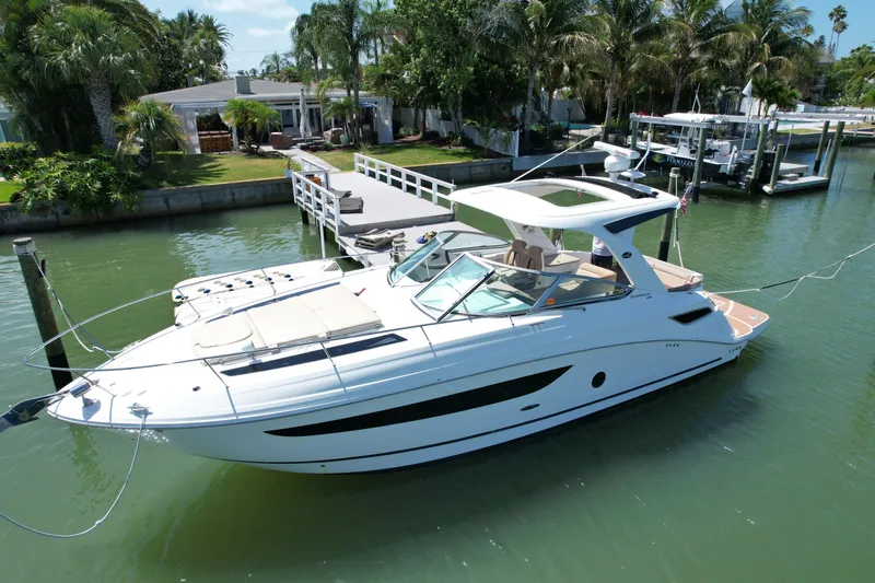 Slide: The Image of 2016 Sea Ray Sundancer 350 yacht docked, surrounded by palm trees. - 14