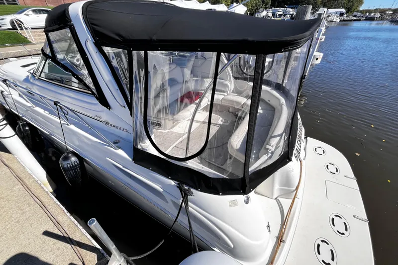 Slide: The Image of 1999 Sea Ray 380 Sundancer docked, featuring a black canopy and spacious seating area. - 5