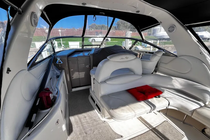 Slide: The Image of 1999 Sea Ray 380 Sundancer interior with white seating and helm, showcasing luxury design. - 7