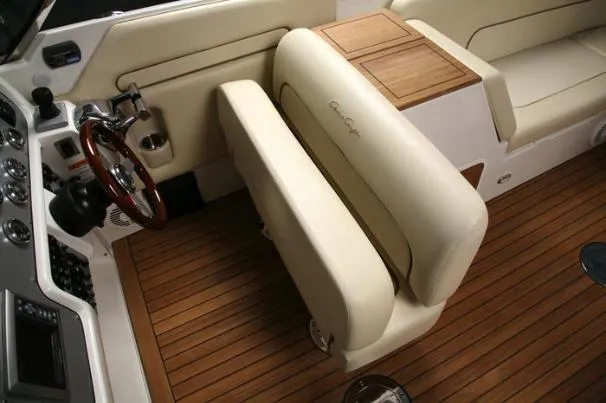 Slide: The Image of 2012 Chris-Craft Launch 28 boat with beige seating, docked near a bridge on a sunny day. - 2