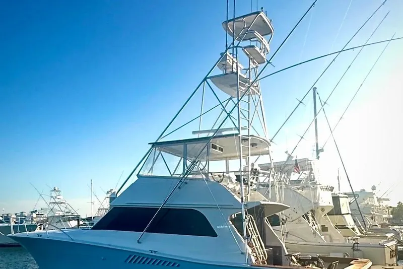 Slide: The Image of 1998 Viking 50 Convertible yacht docked under clear blue sky. - 2