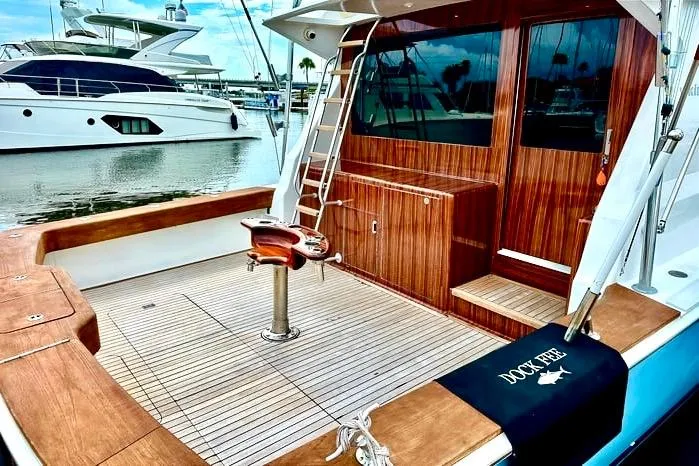Slide: The Image of 1998 Viking 50 Convertible yacht with wooden deck and fishing chair in marina. - 3