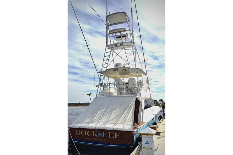 Slide: The Image of 1998 Viking 50 Convertible yacht docked, featuring tall tower and fishing rods. - 4