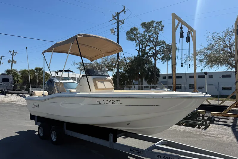 The Image of 2022 Scout 175 Sportfish boat on trailer, parked outdoors under clear sky. - 0