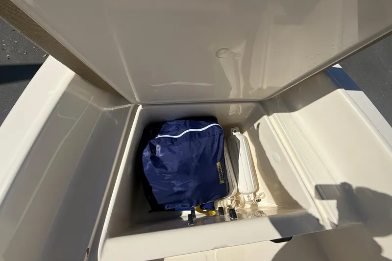 Slide: The Image of Storage compartment of 2022 Scout 175 Sportfish boat with blue bag and accessories. - 15