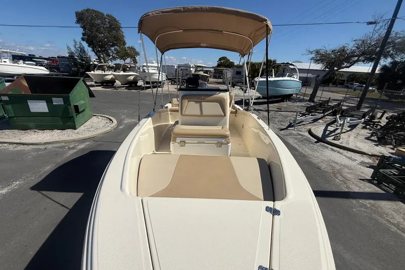 Slide: The Image of 2022 Scout 175 Sportfish boat with beige seating and canopy in a marina setting. - 17