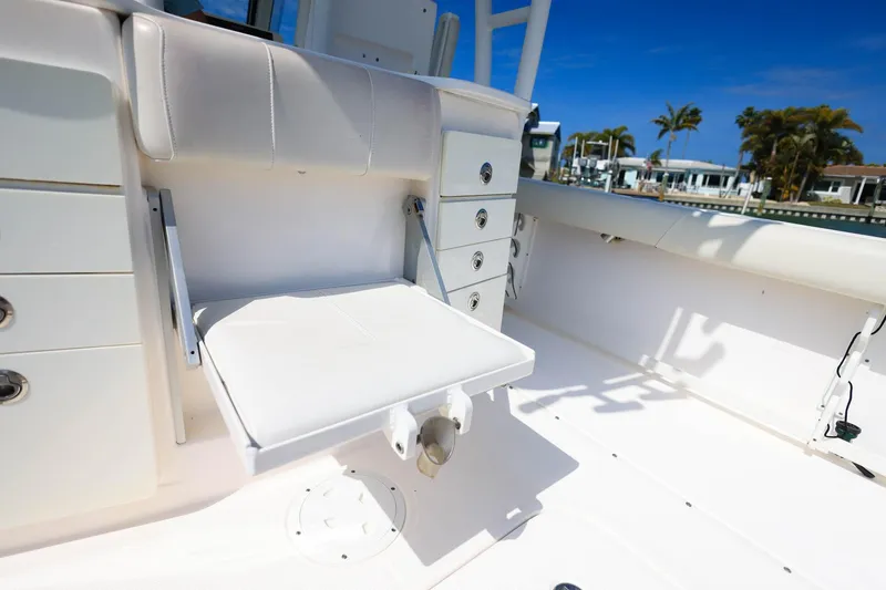 Slide: The Image of 2015 Everglades 355 Center Console boat interior with white seating and storage drawers. - 12
