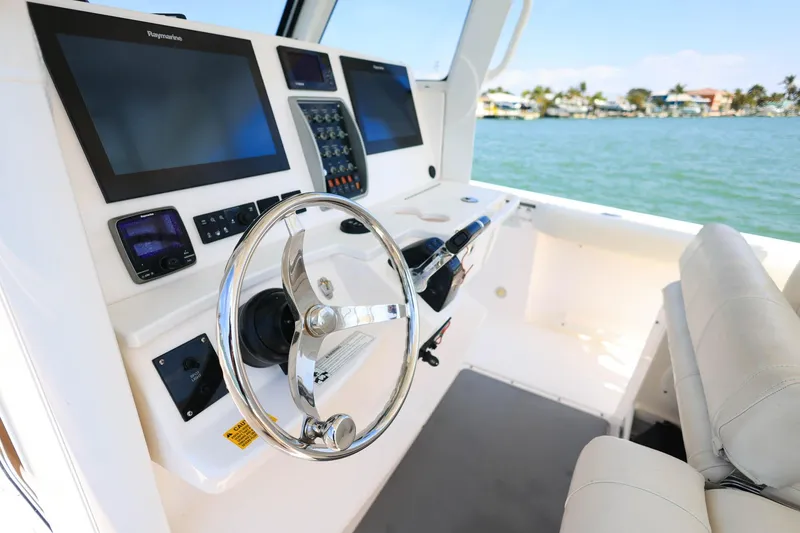 Slide: The Image of 2015 Everglades 355 Center Console boat dashboard with steering wheel and navigation screens. - 13