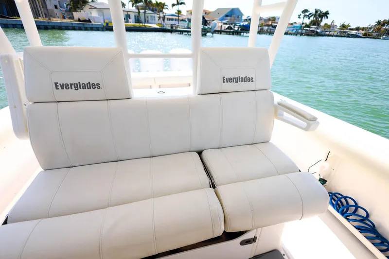 Slide: The Image of 2015 Everglades 355 Center Console boat with white seating, docked by the water. - 19