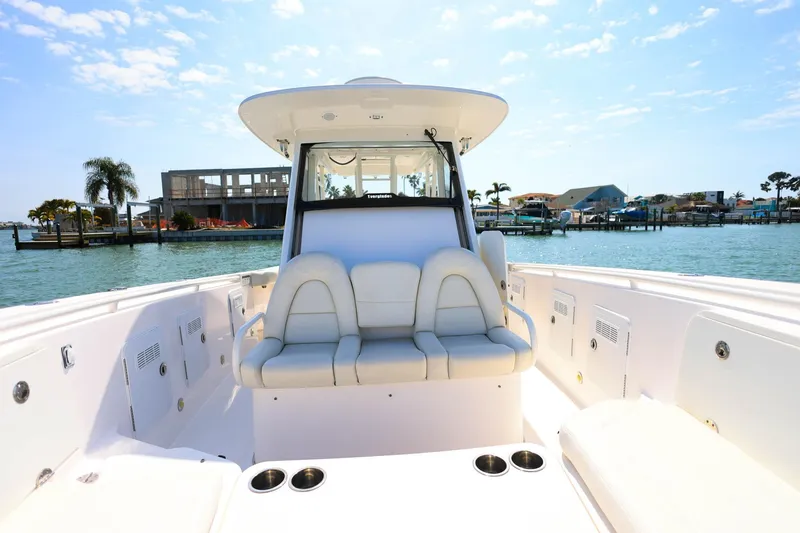 Slide: The Image of 2015 Everglades 355 Center Console boat interior with seating, docked by waterfront homes. - 25