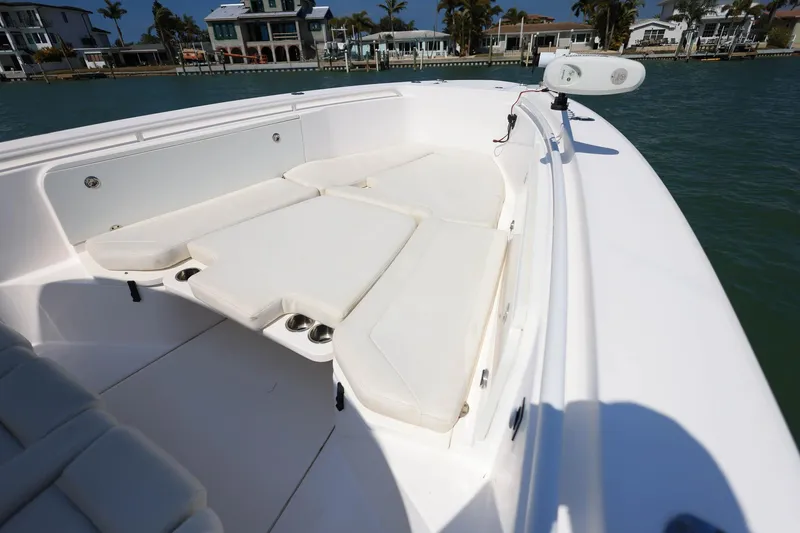 Slide: The Image of 2015 Everglades 355 Center Console boat with cushioned seating, docked near waterfront homes. - 26
