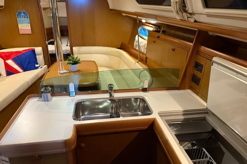 Slide: The Image of Interior of 2007 Jeanneau Sun Odyssey 39i yacht with modern kitchen and cozy seating area. - 39