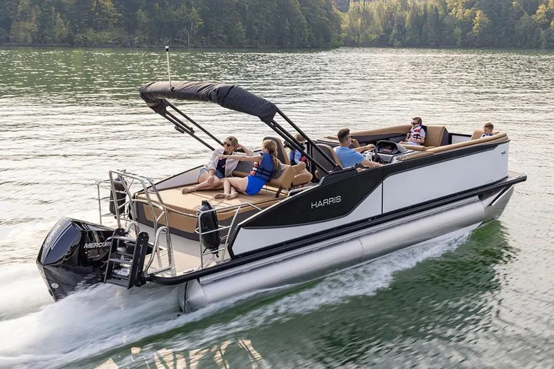 Slide: The Image of Manufacturer Provided Image: 2026 Harris Sunliner 230 pontoon boat cruising on a scenic lake with passengers. - 2