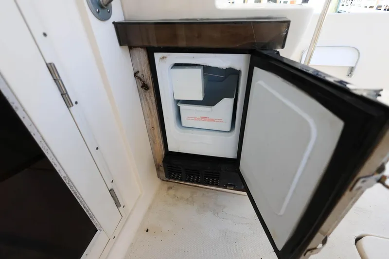 Slide: The Image of Open mini fridge on 2005 Mainship 40 Trawler, showcasing interior storage space. - 10