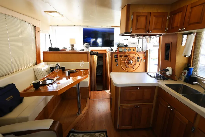 Slide: The Image of 2005 Mainship 40 Trawler interior with dining area, helm, and kitchen. - 12
