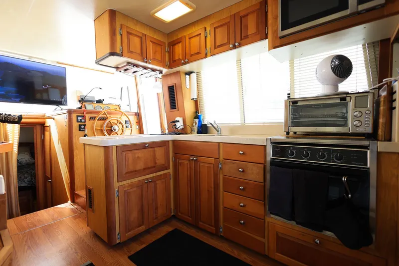 Slide: The Image of 2005 Mainship 40 Trawler kitchen with wooden cabinets, stove, and modern appliances. - 13