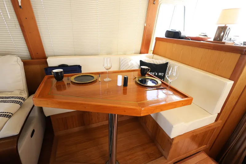 Slide: The Image of Cozy dining area in 2005 Mainship 40 Trawler with wooden table and cushioned seating. - 17
