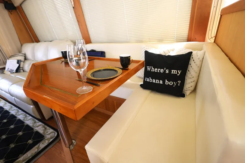 Slide: The Image of Interior of 2005 Mainship 40 Trawler with elegant dining setup and humorous pillow. - 18